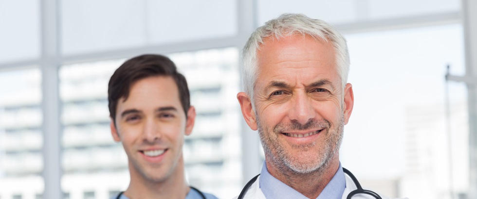 50s, Mature Adult, Man, Male, Caucasian, 20s, Young Adult, Indoors, Looking At Camera, Doctor, Practitioner, Profession, Professional, Specialist, Lab Coat, Stethoscope, Confident, Nurse, Scrubs, Blue, Standing, Clinic, Healthcare, Hospital, Medical, Staff, Attractive, Handsome, Grey Hair, Portrait, Team, Smiling, Happy, Cheerful, Friendly